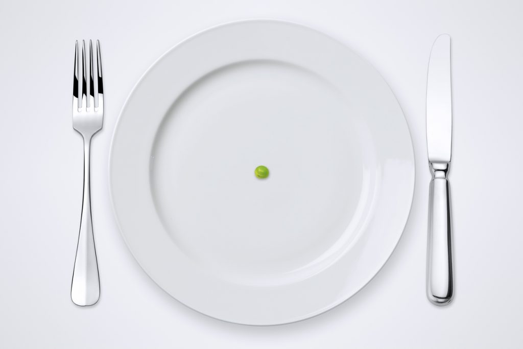 One green pea on plate. Plate, knife and fork with clipping path.