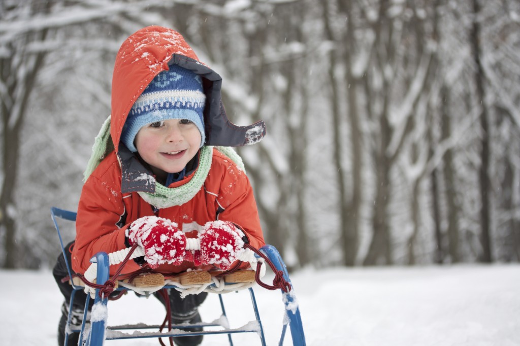 Little boy sliding in the snow