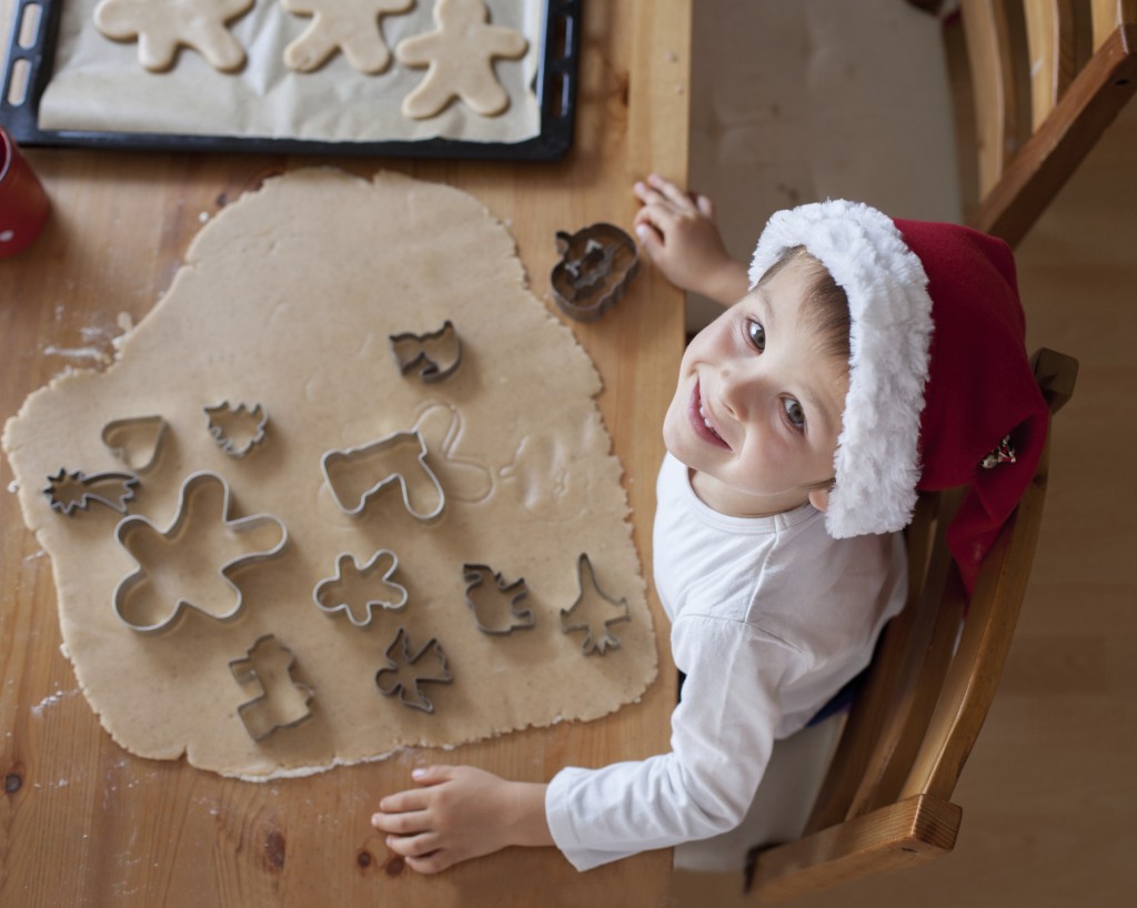 Adorable little boy, preparing cookies for christmas at home, look from above