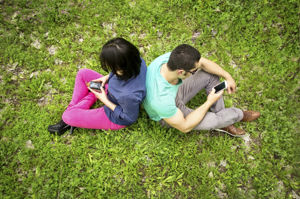couple outside on cell phones