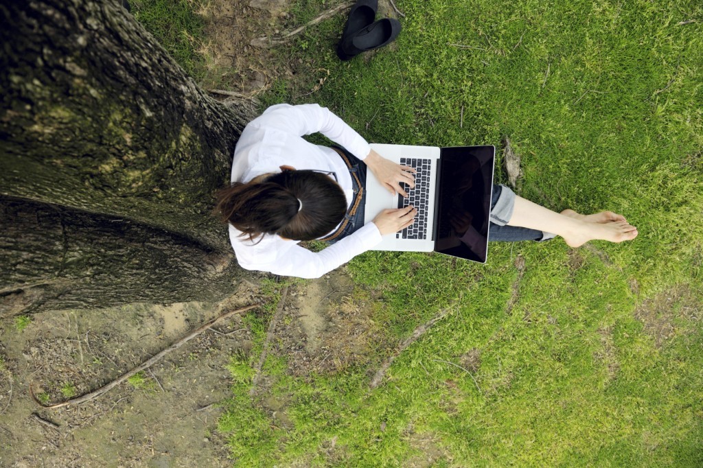 woman with laptop in park