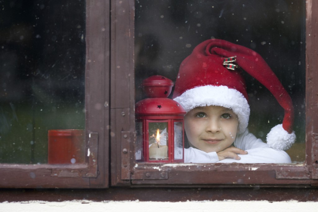 Adorable boy, looking through window, waiting for Santa